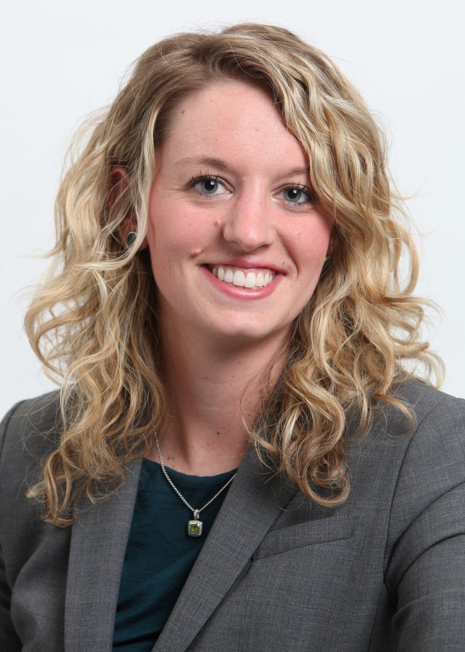 a woman wearing glasses and smiling at the camera